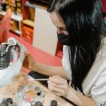 woman painting sneakers for a personalized gift